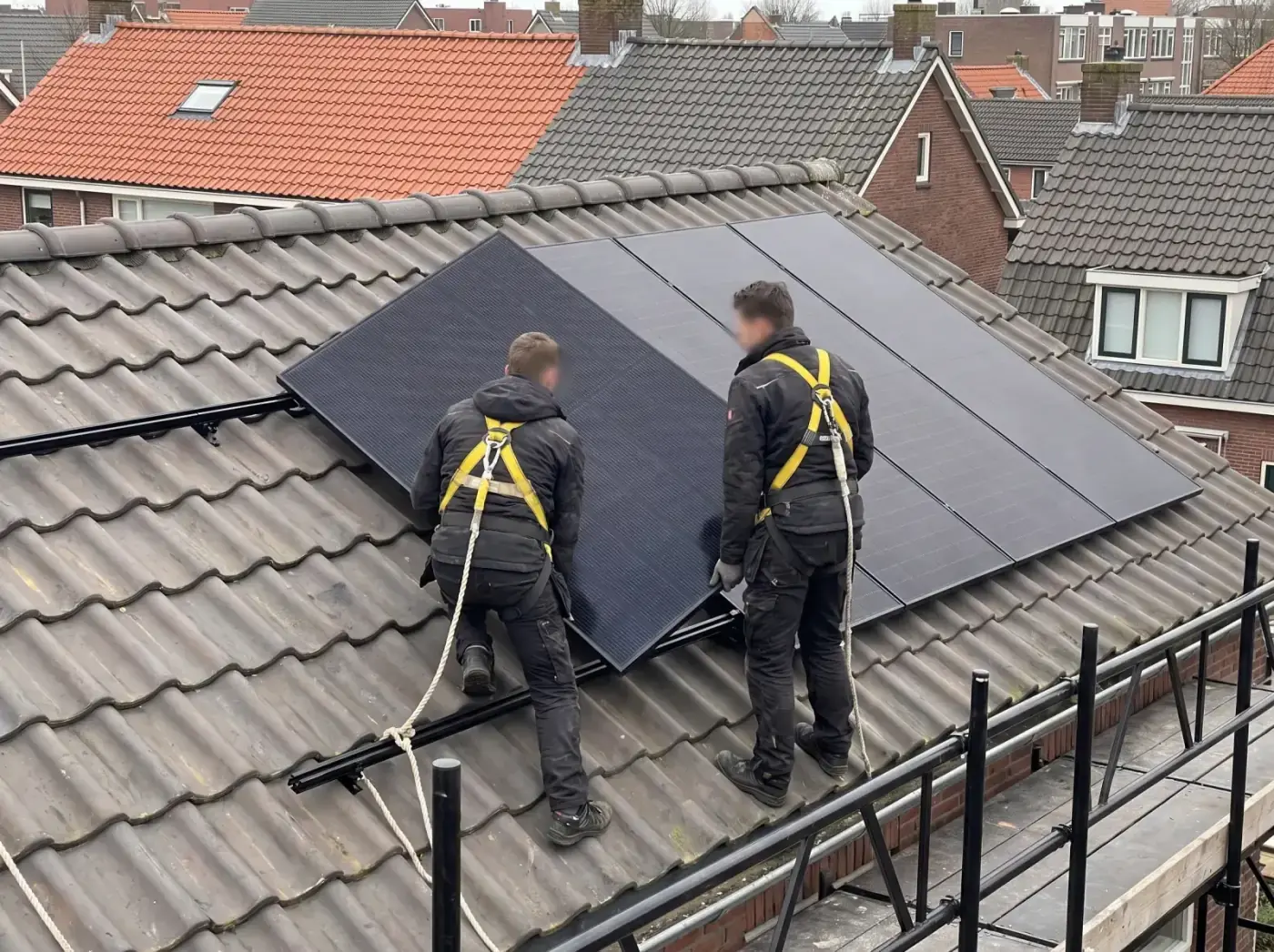 Monteurs leggen full-black zonnepanelen op een pannendak