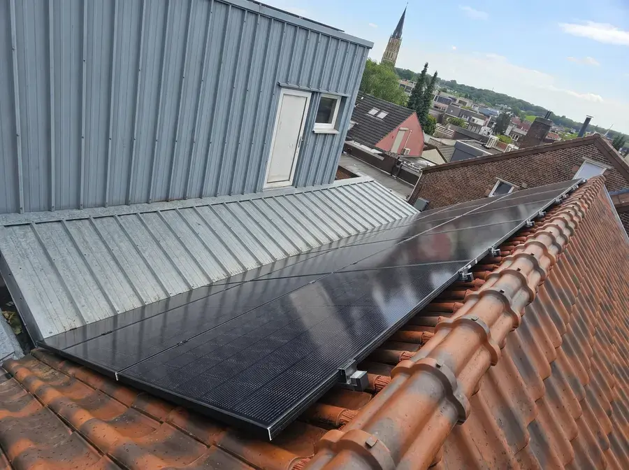 Zonnepanelen op een pannendak naast een metalen dakopbouw